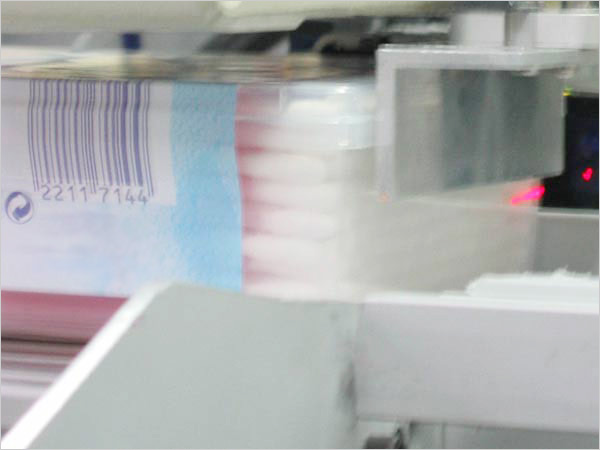 Eine mechanische Vorrichtung hält die Produktbox fest, die Kamera wertet das Bild aus.